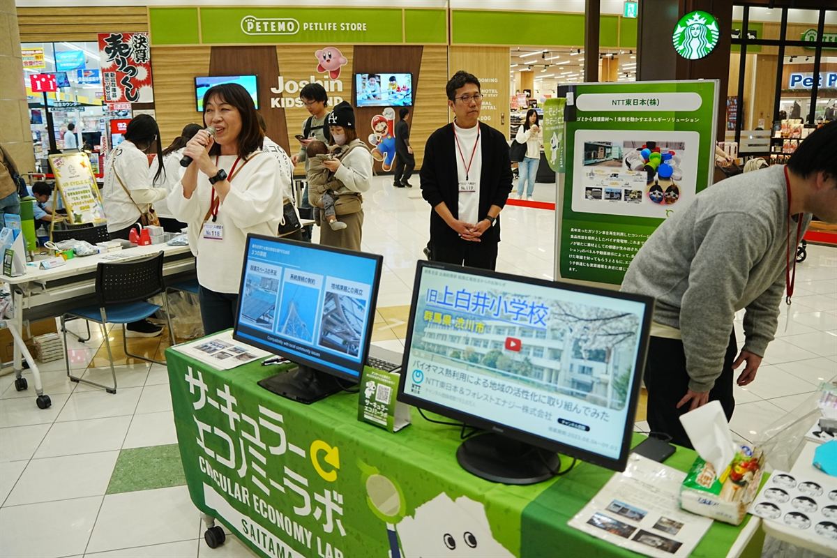 NTT東日本のブースでモニター展示を見る来場者